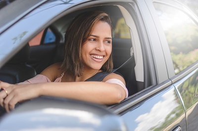 Portrait of young woman driving a car