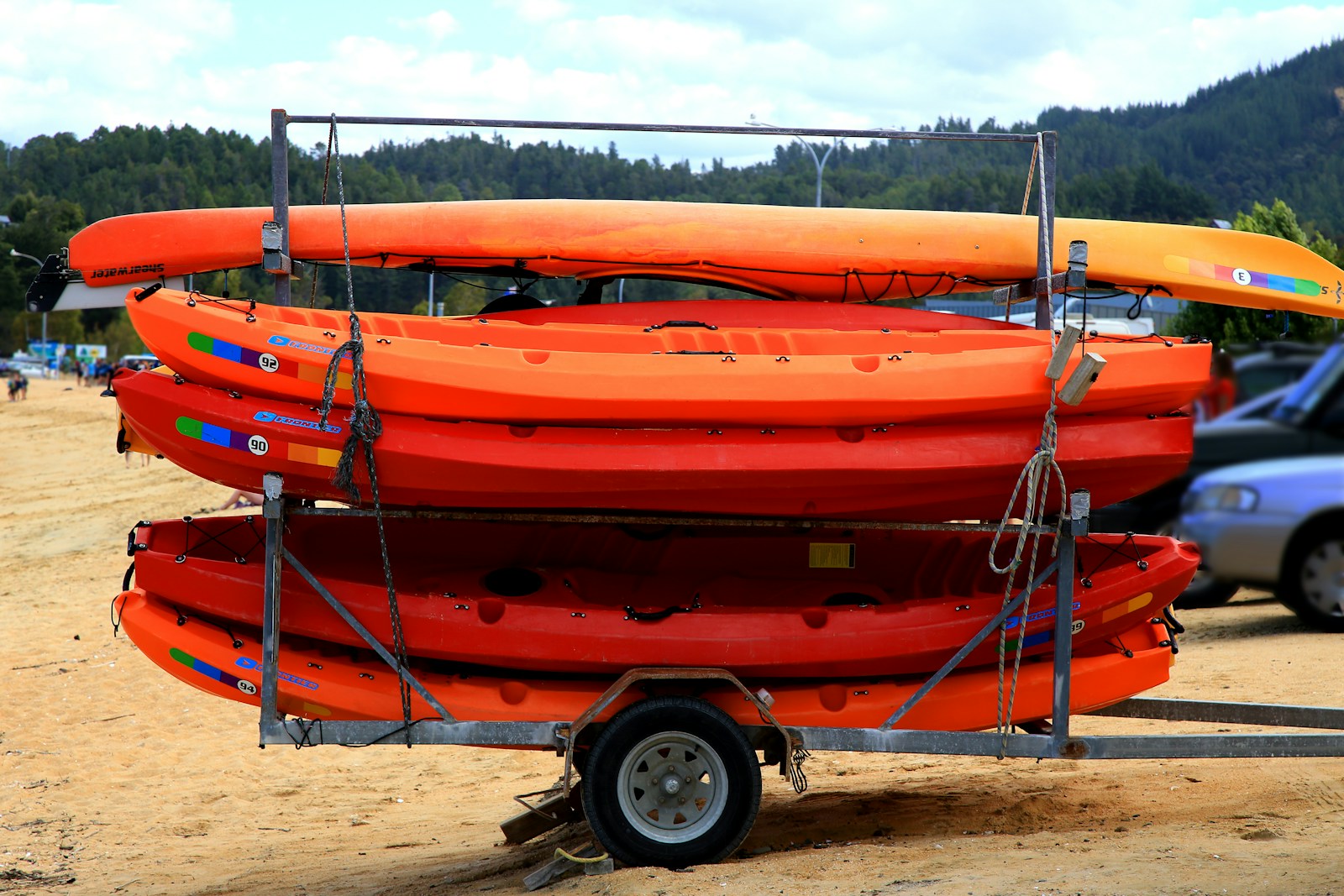 boat insurance orange and black kayak on brown sand during daytime