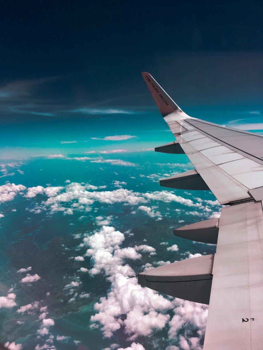 Airplane Wing Above Clouds, travel insurance